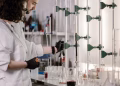 Scientists in lab coats work with test tubes in a modern laboratory.
