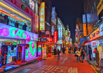 Explore the vibrant nightlife of Seoul's bustling street with colorful neon signs and lively atmosphere.