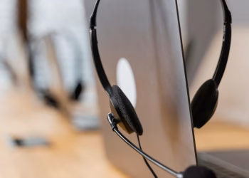 Close-up of a headset resting on a laptop, symbolizing efficient work environment technology.