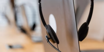 Close-up of a headset resting on a laptop, symbolizing efficient work environment technology.