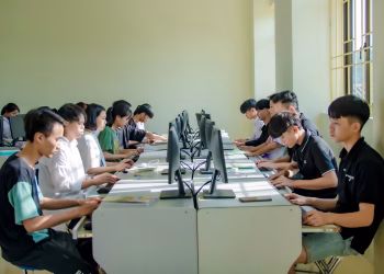 A group of students in a classroom focused on computer screens, fostering digital education.