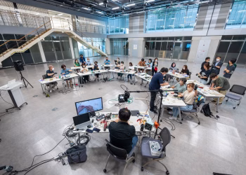 Wide shot of students in a modern university classroom engaging with technology and learning.