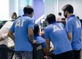 man in blue nike crew neck t-shirt standing beside man in blue crew neck t