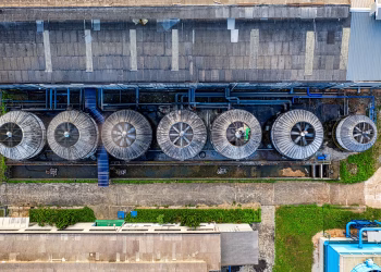 Drone view of industrial terrain with treatment plants located in suburban area in sunlight