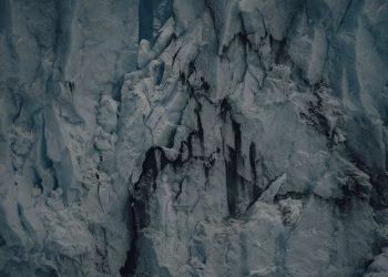 Detailed view of a rugged glacier with cracks and textures, showcasing icy formations.