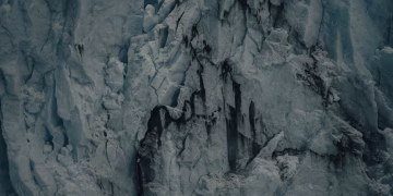 Detailed view of a rugged glacier with cracks and textures, showcasing icy formations.