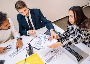 Business professionals engaging in a collaborative meeting with charts and documents.