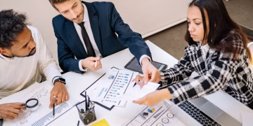 Business professionals engaging in a collaborative meeting with charts and documents.