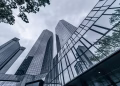 Modern skyscrapers with glass facades reflecting the urban skyline on an overcast day.