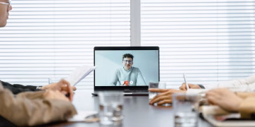 A diverse group participates in a virtual meeting using modern technology.