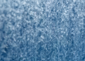 Detailed macro shot of intricate frost texture on a window during winter.