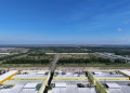 Aerial shot of industrial buildings and green landscape in Bình Dương, Vietnam under a clear blue sky.