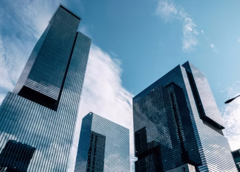 Low-angle view of modern skyscrapers reaching into a clear blue sky, capturing urban architecture.