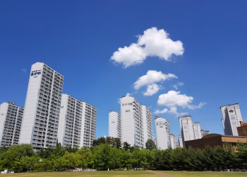 Skyline of high-rise apartments in Yongin with clear blue sky and clouds.