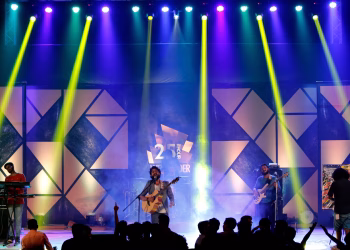 Energetic live band performance on stage with dynamic lighting at night.