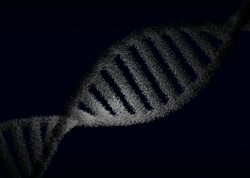 Artistic rendering of a DNA strand with particle effects against a dark background.