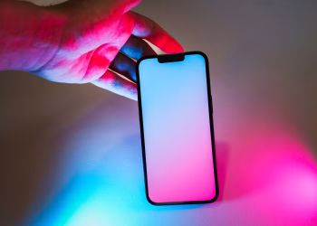 Smartphone with neon pink and blue glow, offering ample copy space for design mockups.