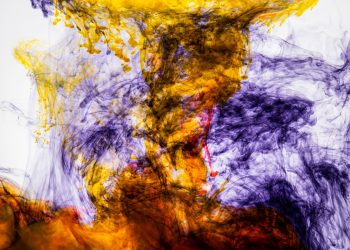 A vivid abstract image of colorful ink swirling through water, creating dynamic patterns and textures.