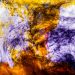A vivid abstract image of colorful ink swirling through water, creating dynamic patterns and textures.