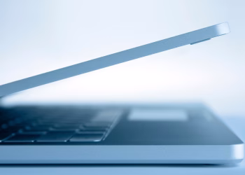 Profile view of a sleek modern laptop in a minimalist style, highlighting its slim design and technology focus.