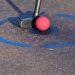 red golf ball on brown and white concrete pavement
