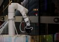 A white robotic arm operating indoors with a modern design and advanced technology.
