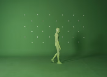 Person walking in a chroma key suit in a studio with green screen for video editing.