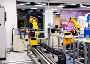 Robotic arms in action within a modern industrial control room setting, showcasing technology and production.