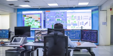 Operator in a modern control room managing technological systems in El Agustino, Lima.