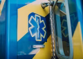 Vibrant blue and yellow medic symbol on an ambulance door, representing emergency medical services.