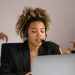 Customer support agent with headset working on laptop in office.