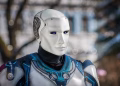Close-up of a futuristic humanoid robot with metallic armor and blue LED eyes.