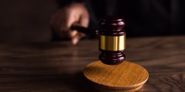 A gavel striking a sound block, symbolizing justice and legal authority in a courtroom setting.
