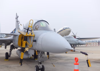 Close-up view of a fighter jet parked at an airport during the day.