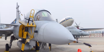 Close-up view of a fighter jet parked at an airport during the day.