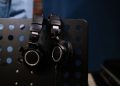Close-up of professional headphones hanging on a perforated music stand in a studio setting.