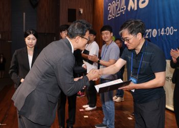 A man is accepting an award and shaking hands.