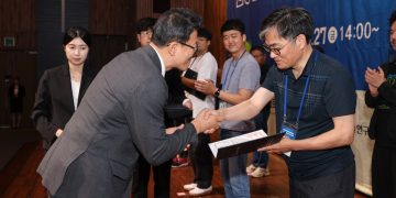 A man is accepting an award and shaking hands.