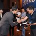 A man is accepting an award and shaking hands.