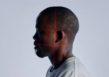 Side profile portrait of an adult man with laser scanning lines on face, showcasing advanced recognition technology.