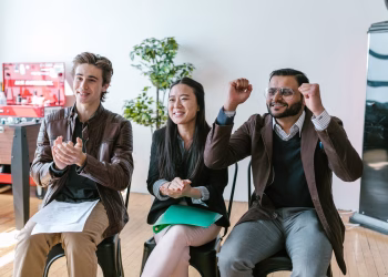A group of diverse entrepreneurs in a workspace celebrating success and motivation.