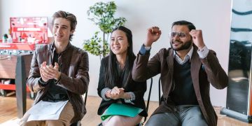 A group of diverse entrepreneurs in a workspace celebrating success and motivation.