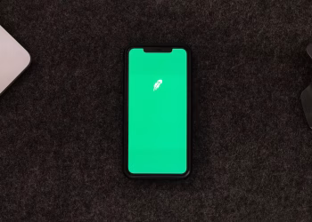 Smartphone displaying trading app on a desk for stock finance concepts.