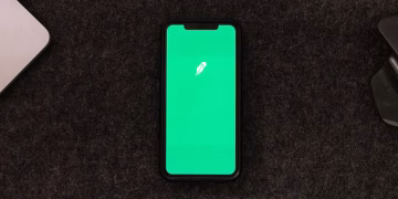 Smartphone displaying trading app on a desk for stock finance concepts.