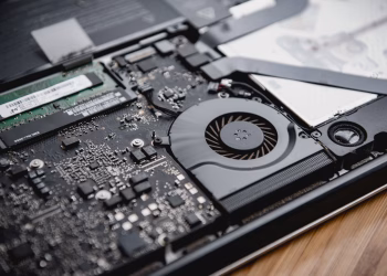 Detailed view of a laptop's internal circuitry and cooling fan showcasing technology and engineering.