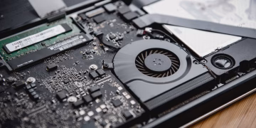 Detailed view of a laptop's internal circuitry and cooling fan showcasing technology and engineering.