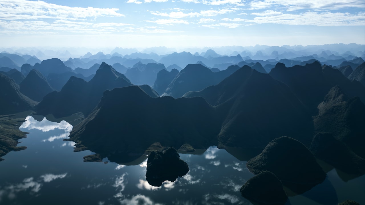 Misty blue mountains reflected in calm water