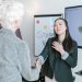 Professional women shaking hands in a corporate office setting, symbolizing a successful business agreement.