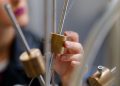 A student conducting an interactive physics experiment with brass components.