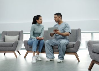Healthcare provider consulting a patient with a tablet, emphasizing technology in healthcare.